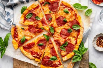 Close-up of pepperoni cottage cheese pizza with melted cheese and basil.