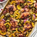 Roasted cranberry balsamic chicken with caramelized veggies on a sheet pan ready to serve.