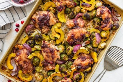 Roasted cranberry balsamic chicken with caramelized veggies on a sheet pan ready to serve.