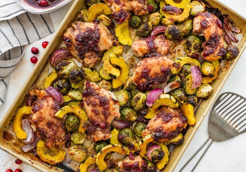 Roasted cranberry balsamic chicken with caramelized veggies on a sheet pan ready to serve.