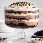 Assembled chocolate trifle showing layers of brownies, pudding, and whipped topping in a glass dish.