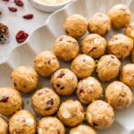 A white dish of cranberry orange protein balls.