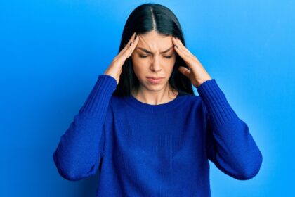 Why do some migraines cause flashing lights or temporary blindness?