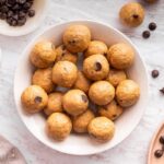 Overhead view of a full bowl of peanut butter protein balls ready for snacking.