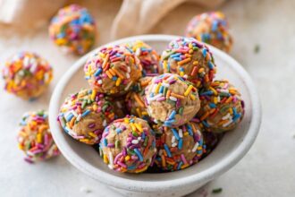 A bowl full of birthday cake protein balls with colorful sprinkles.