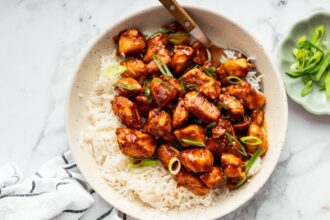 Sweet and savory glazed chicken served over fluffy rice in a bowl.
