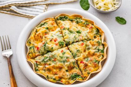High-protein tortilla quiche sliced into wedges in white pie dish, ready to serve.