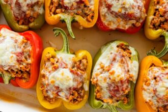 A pan of cooked turkey stuffed peppers with melted cheese.