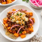 Roasted sweet potatoes topped with ground beef, street corn salsa, pickled red onions, cilantro and hot honey.
